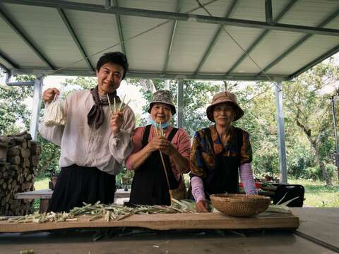 圖4-主持人與馬佛社區阿姨們一同剝箭筍，開心展示午餐備料成果。